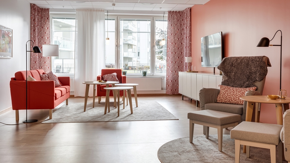 Vardagsrum med soffgrupp framför tv.