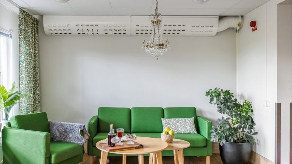 En fåtölj och en soffa bakom ett soffbord, dukat för fika.