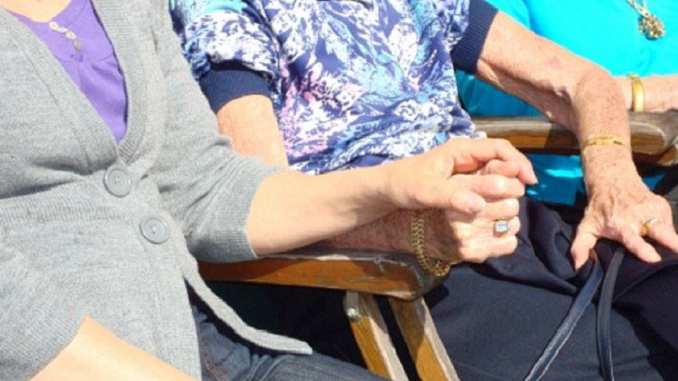Ett par personer sitter bredvid varandra och håller handen